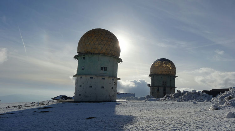 Radar domes covered by snow at Torre, the highest point of Serra da Estrela, Portugal. The mountain landscape is a popular destination for winter activities and panoramic views.
