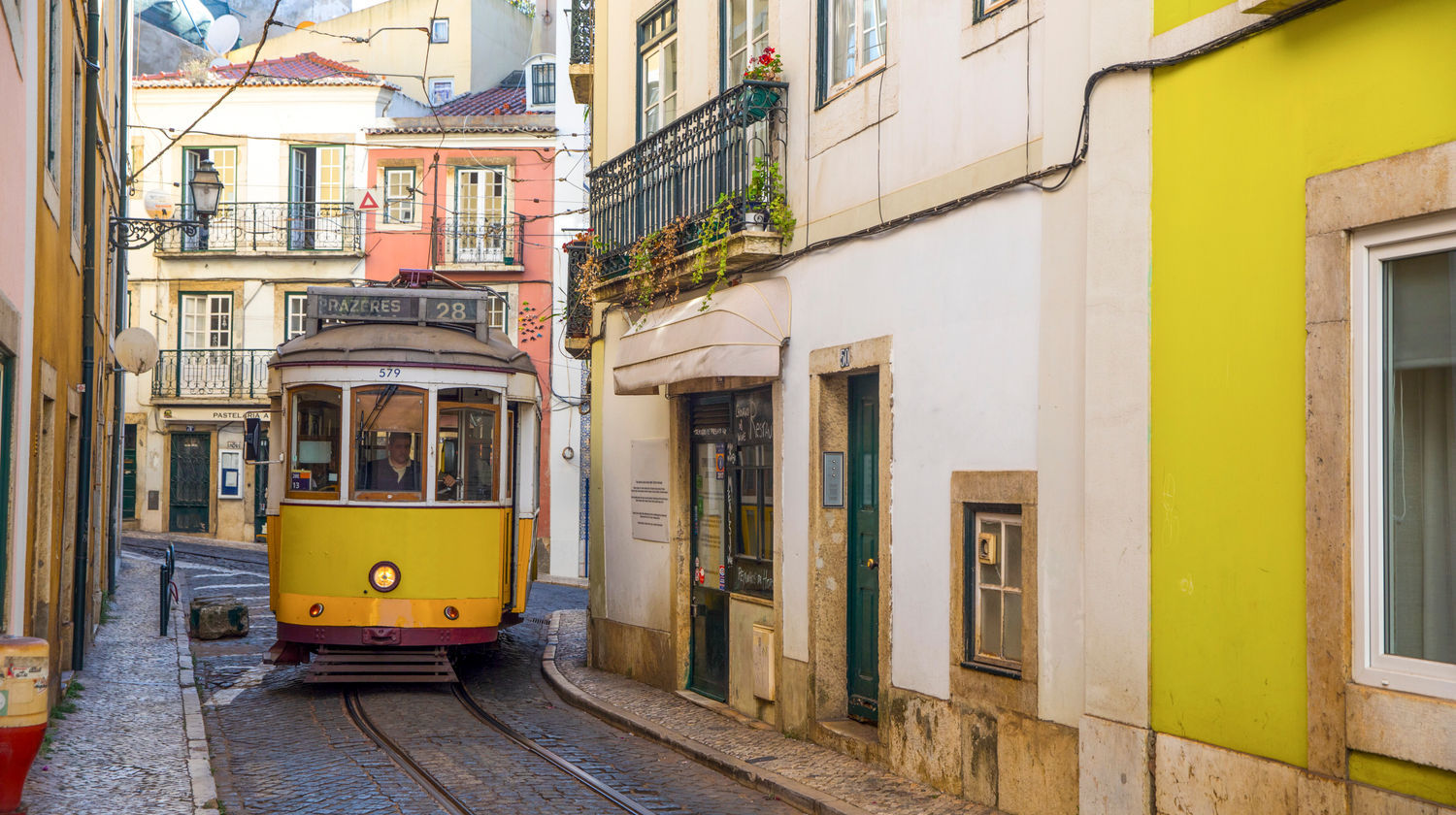 Yellow Tram 28 navigating the narrow, historic streets of Lisbon