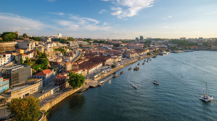 Panoramic view of Porto's Ribeira District along the Douro River in Porto, Portugal. Historic riverside buildings, traditional rabelo boats, and the UNESCO-listed waterfront create one of the city's most iconic landscapes.