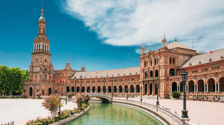 Scenic view of the Plaza de España in Seville with its canal, bridges, and Renaissance-style architecture.