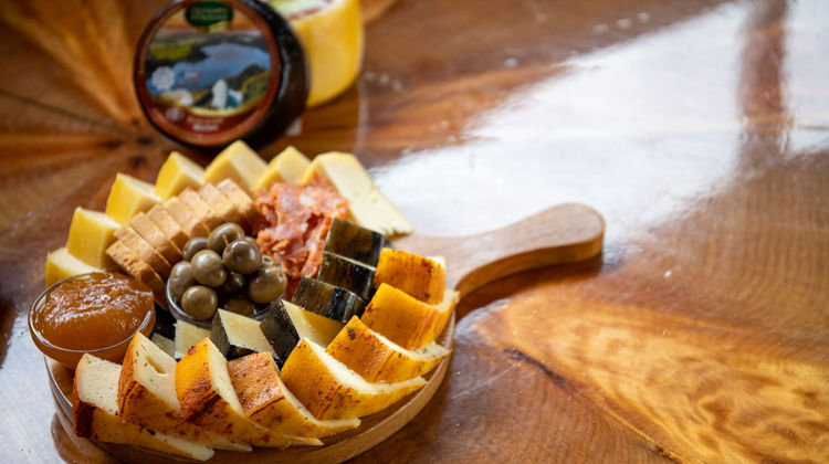 Wooden board with Azorean cheese, olives, and local delicacies on São Miguel Island.