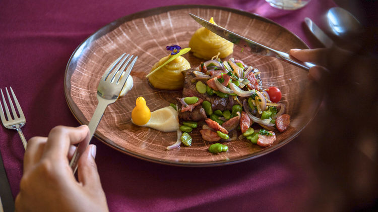 Plate with local meat dish garnished with potatoes and herbs, typical Terceira Island cuisine.