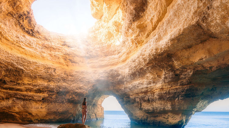 Interior view of the Benagil Cave in Algarve, Portugal, showing the iconic rock formations and natural skylight above the beach.