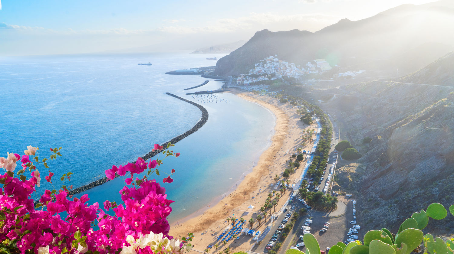 View over Playa de las Teresitas in Tenerife, Canary Islands, Spain, showing the curved beach, ocean, and surrounding hills.