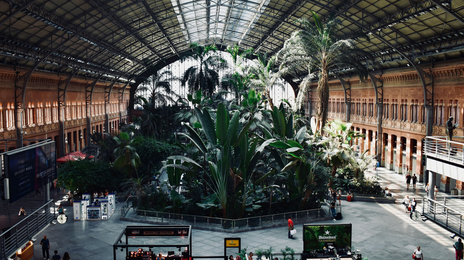 Entrada do metro na Plaza de España em Madrid ao pôr do sol, com luz dourada e movimento urbano