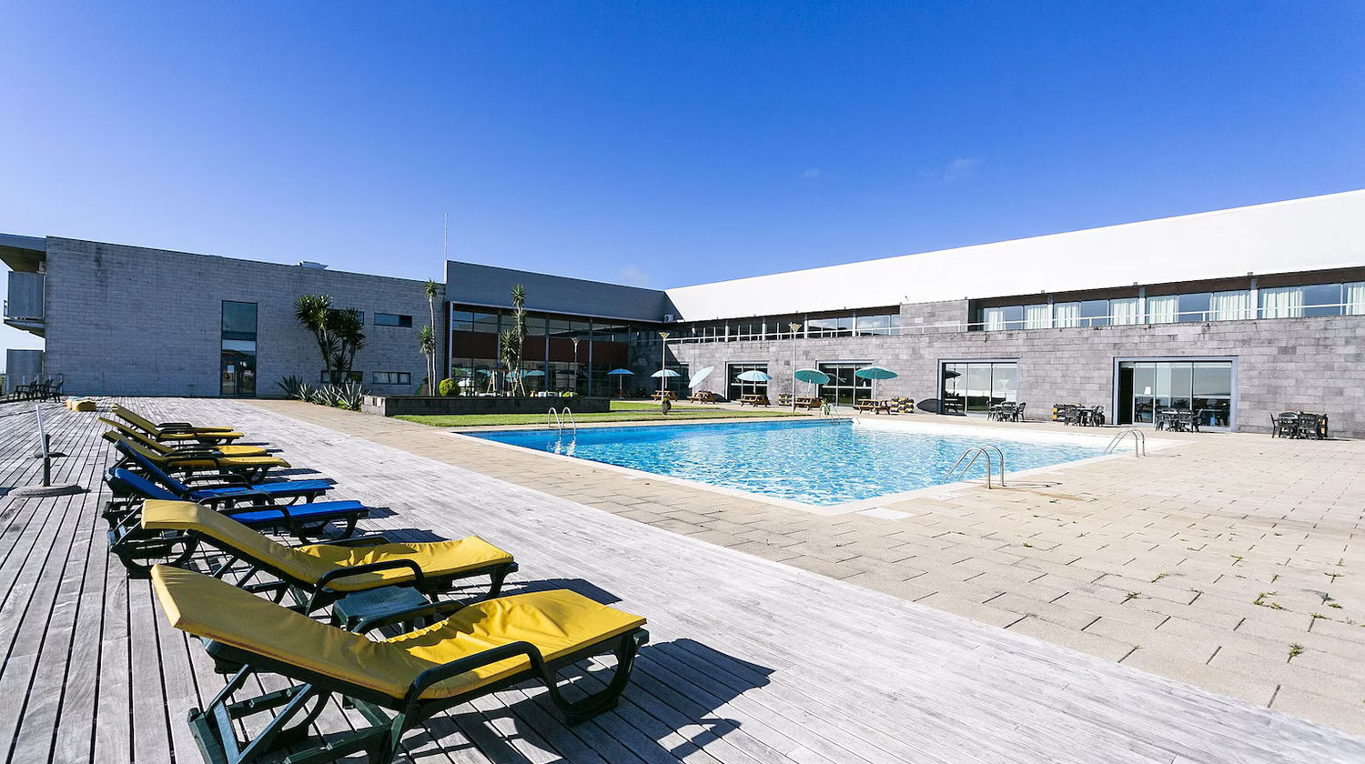 Piscina exterior do Hotel Colombo em Santa Maria, Açores, com espreguiçadeiras e zona de lazer