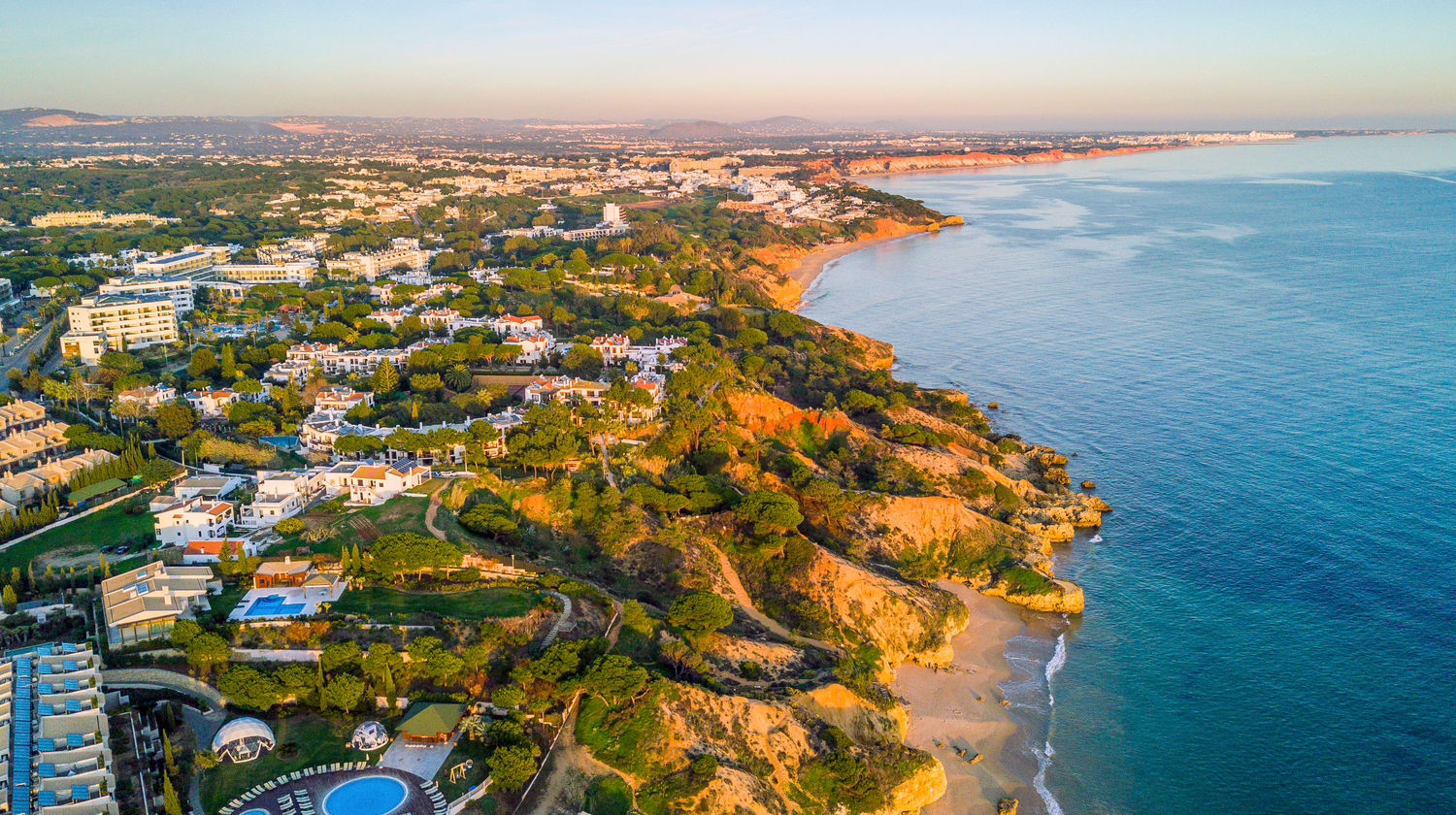 Aerial view of the Algarve’s south coast, showing golden sandy beaches, rugged cliffs, and seaside towns overlooking the Atlantic.