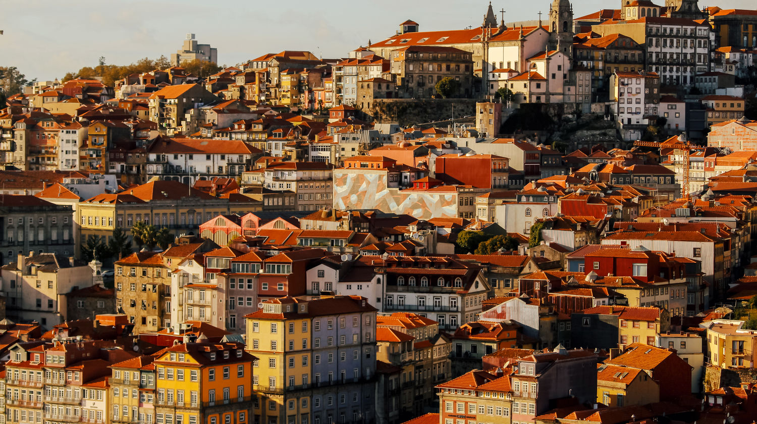 The terracotta rooftops of Porto’s historic center at golden hour.