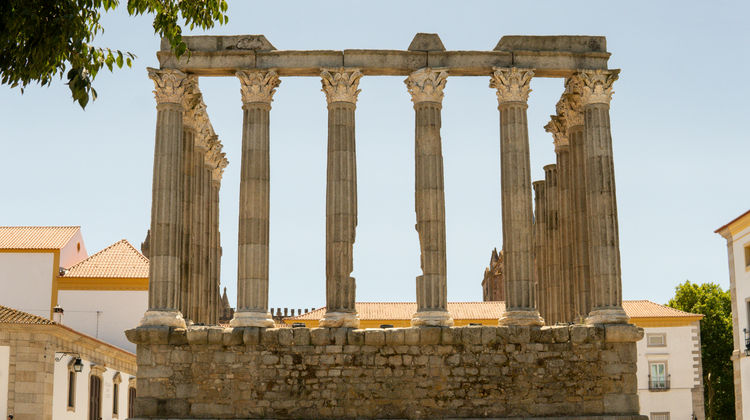 Ancient Roman Temple of Évora, also known as the Temple of Diana, with Corinthian columns set against a blue sky in Évora, Portugal.