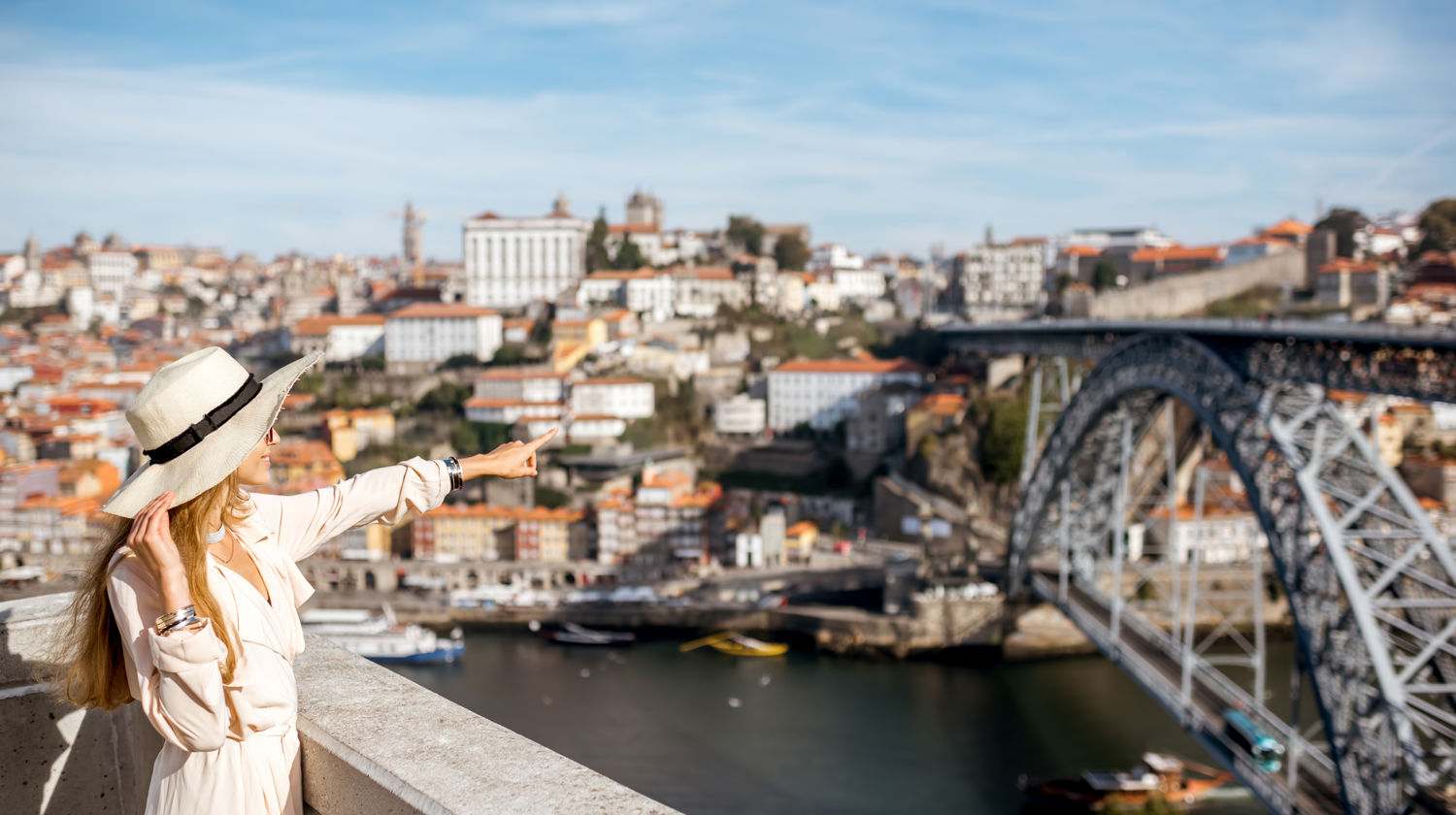 Woman admiring the panoramic view of Dom Luís I Bridge and the Douro River in Porto, Portugal.