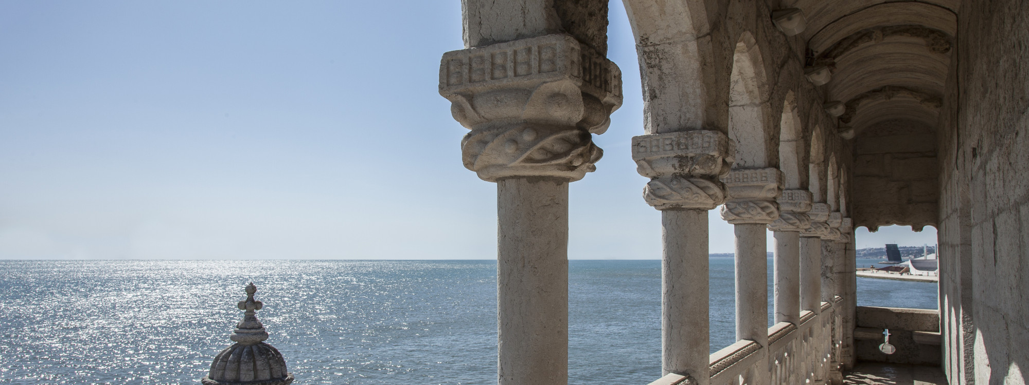 Stone arched loggia of the Torre de Belém overlooking the Tagus River on a sunny day in Lisbon, Portugal