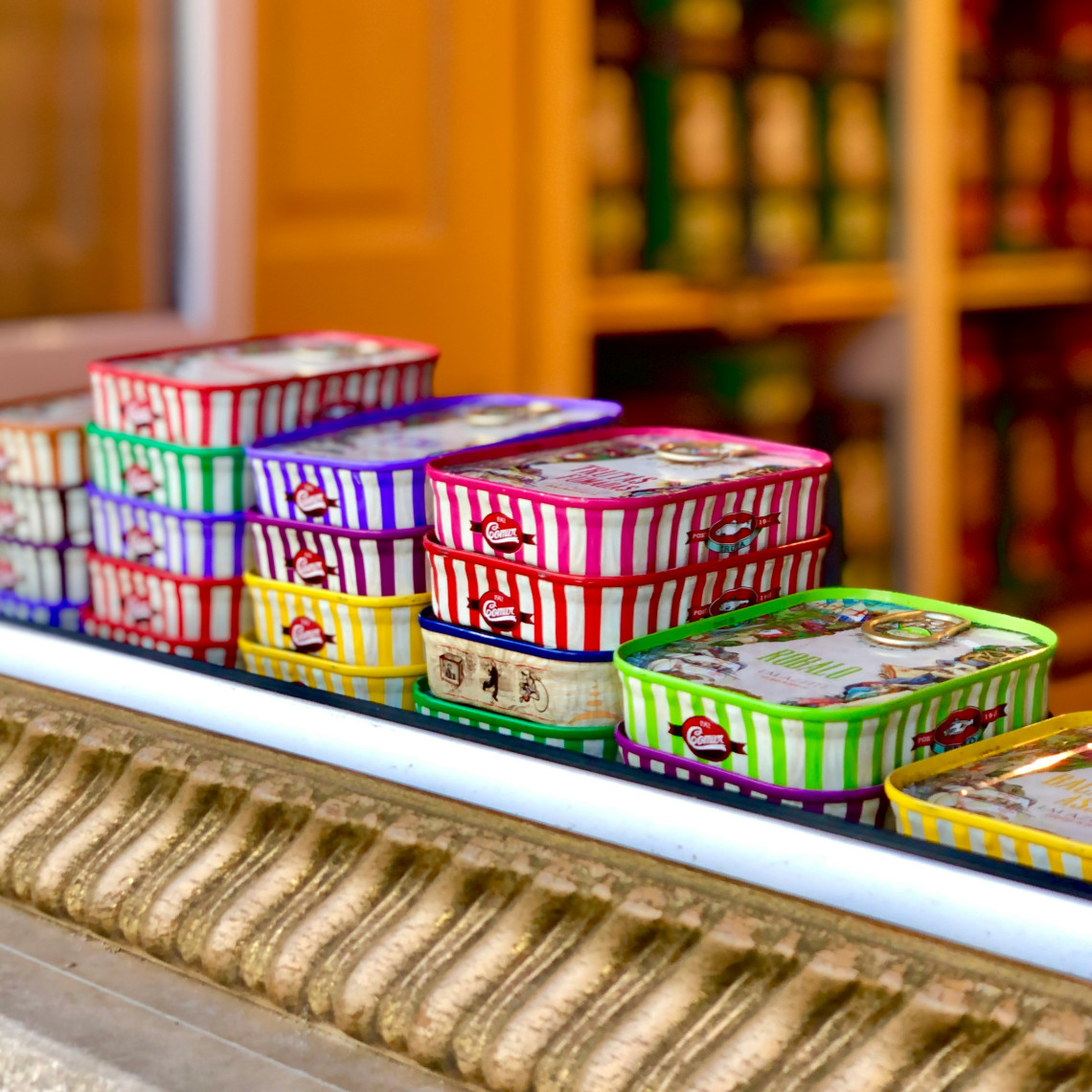 Colourful striped Portuguese canned sardine tins stacked on display in a traditional Lisbon souvenir shop