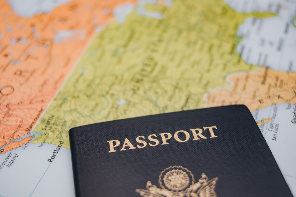 US passport placed on a colorful world map, symbolising international travel and adventure