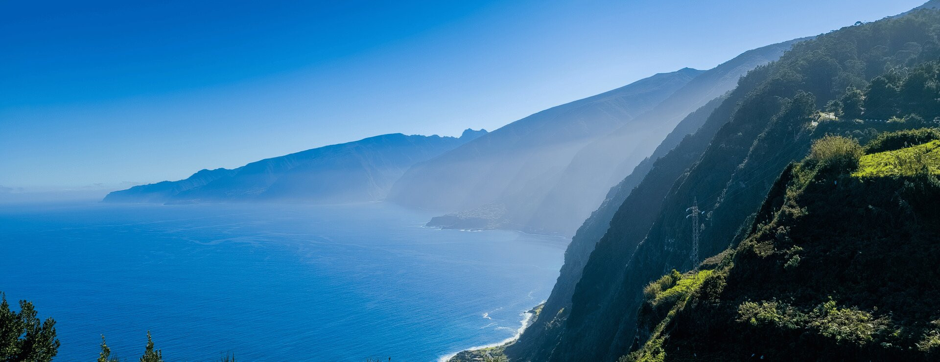  Dramatic tall green sea cliffs on the north coast of Madeira rising steeply from the deep blue Atlantic Ocean