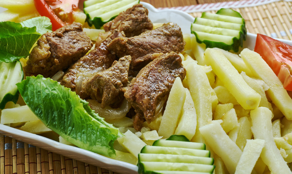 Picado from Madeira Island, Portugal, served with seasoned beef pieces, fries, lettuce, cucumber, and tomato. The image shows a traditional Madeiran sharing dish commonly served in casual restaurants and bars.