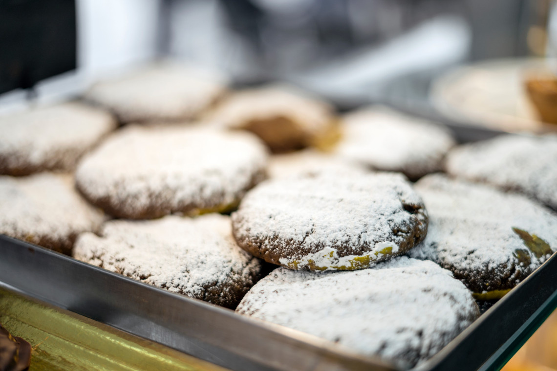 Broas de Mel from Madeira Island, Portugal, displayed in a pastry tray and dusted with powdered sugar. The image shows traditional Madeiran honey biscuits often associated with the island’s local sweets and bakery culture.