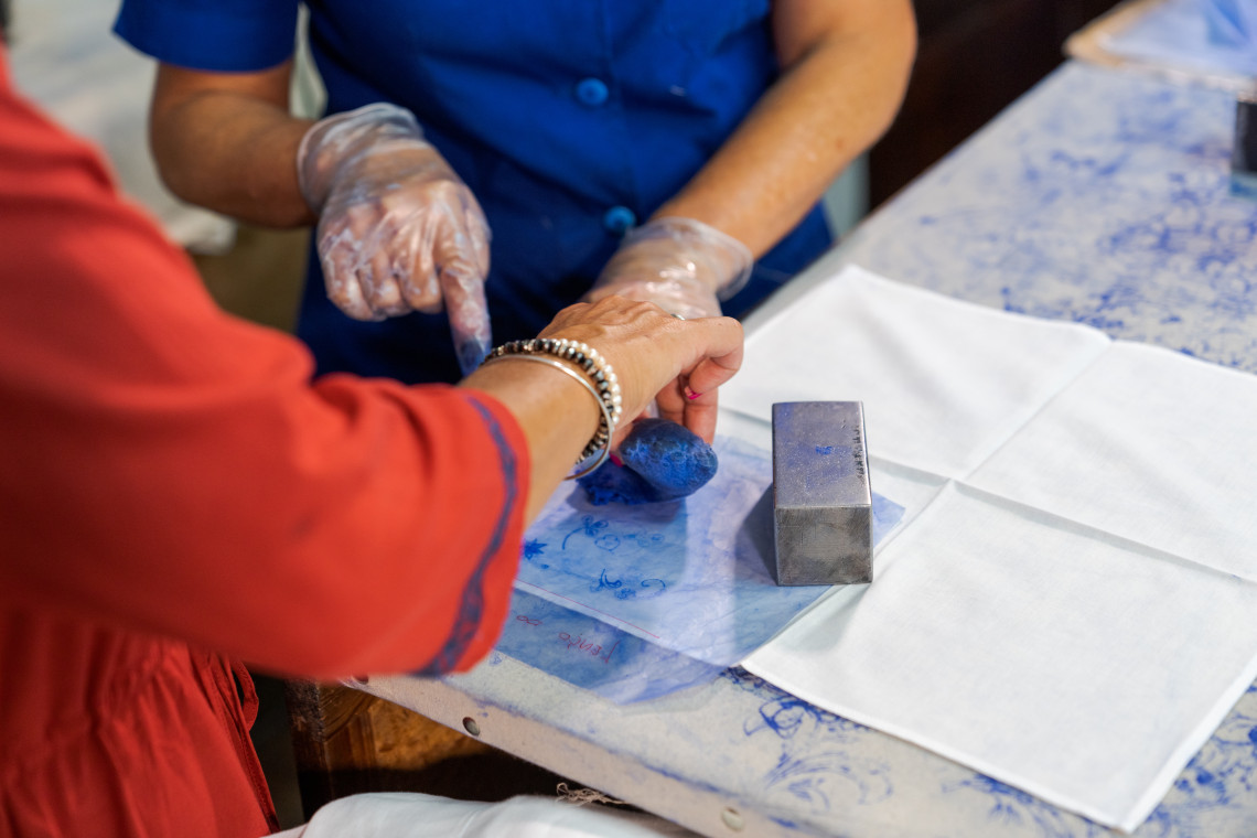 A visitor takes part in a Madeira embroidery workshop on Madeira Island, Portugal, watching the traditional craft process up close. The image shows a cultural experience connected to Bordado Madeira, one of the island&rsquo;s best-known handmade traditions.