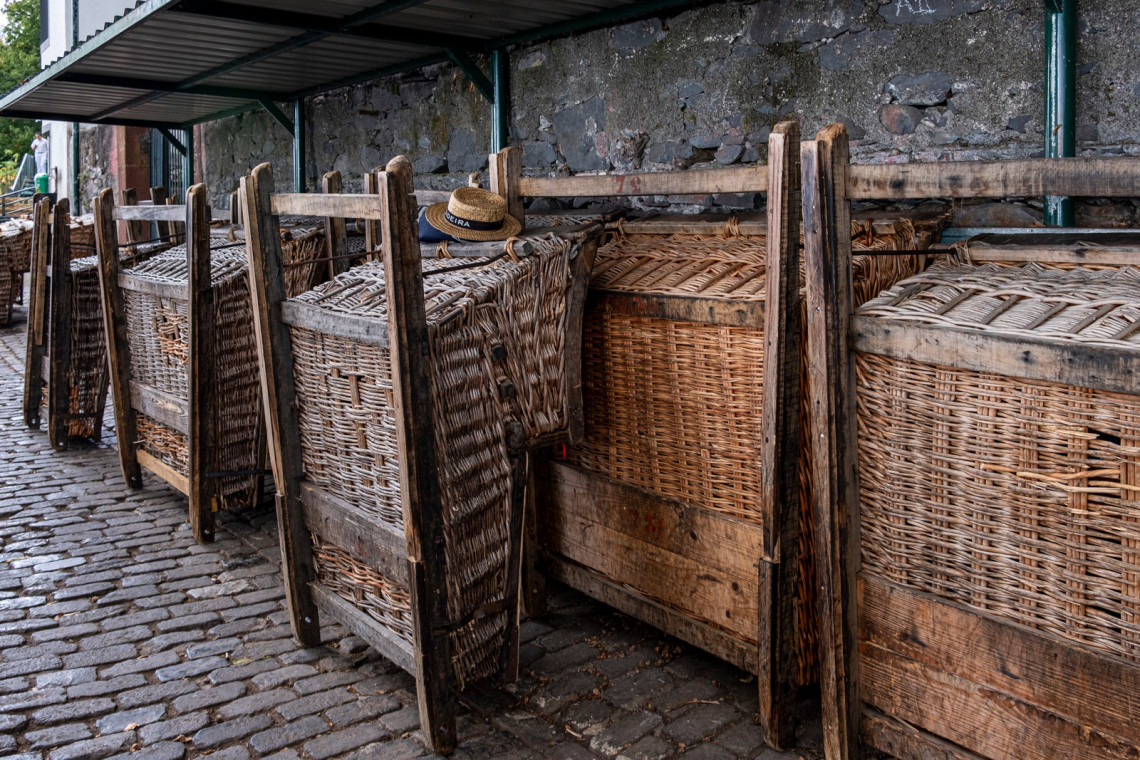 Traditional wicker toboggan baskets are lined up in Monte, Funchal, Madeira, Portugal, ready for the downhill ride through the city streets. Their woven construction and wooden runners reflect one of Madeira&rsquo;s best-known transport traditions.