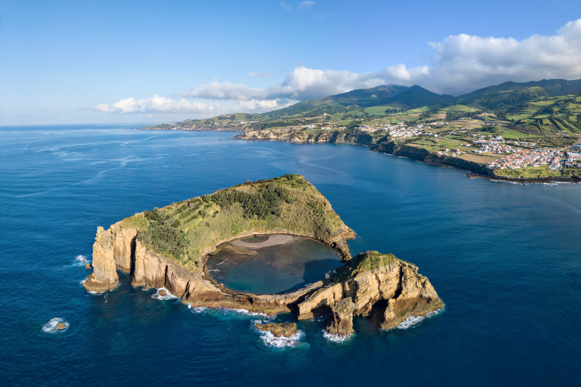 Aerial view of Ilh&eacute;u de Vila Franca do Campo off the south coast of S&atilde;o Miguel Island in the Azores, Portugal. The volcanic islet surrounds a natural circular lagoon, with Vila Franca do Campo and the island&rsquo;s green coast