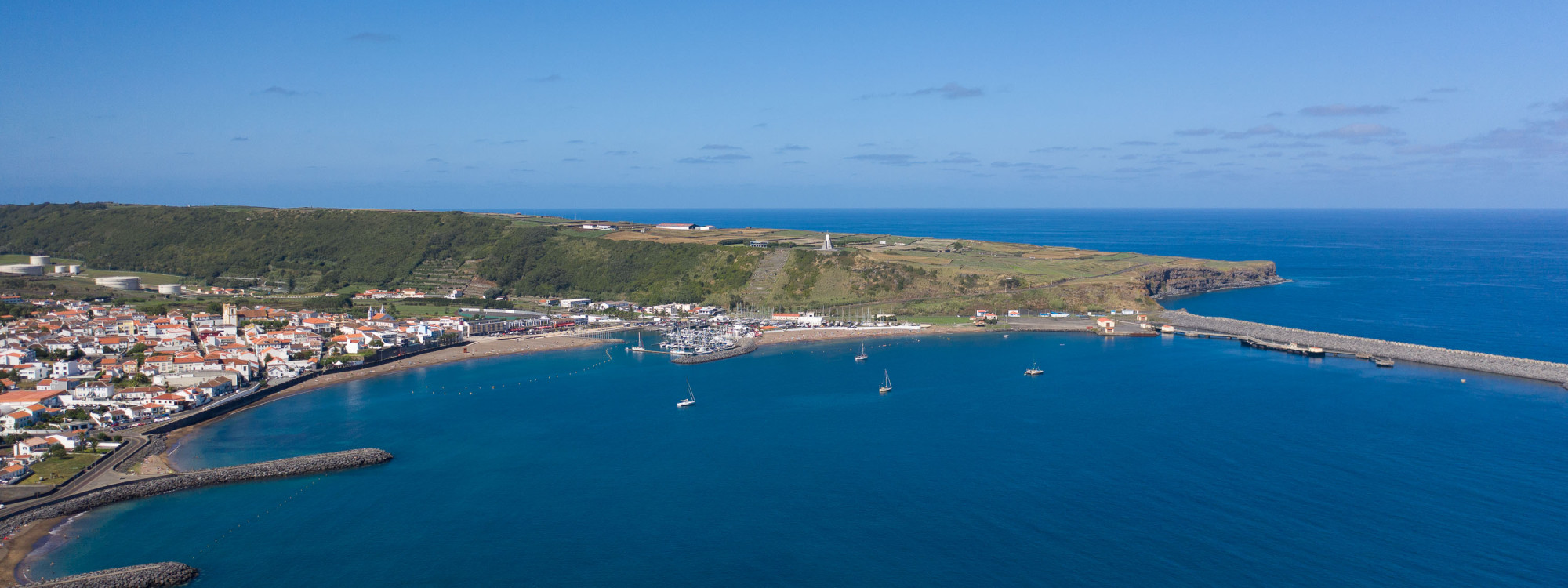 Aerial view of Praia da Vitória in Terceira Island, Azores, showing the marina, coastline, blue ocean, and surrounding town on a sunny day.