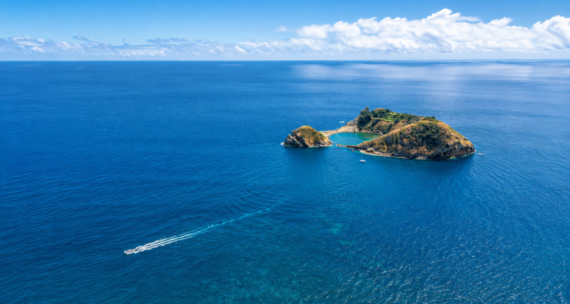 Aerial view of Ilh&eacute;u de Vila Franca do Campo on S&atilde;o Miguel Island, Azores, Portugal. The volcanic islet is surrounded by the deep blue Atlantic Ocean and shelters a natural lagoon, one of the Azores' most iconic coastal landmarks.
