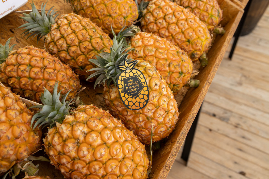 Fresh Anan&aacute;s dos A&ccedil;ores displayed at the pineapple plantation in Ponta Delgada, S&atilde;o Miguel Island, with a branded local-produce label.