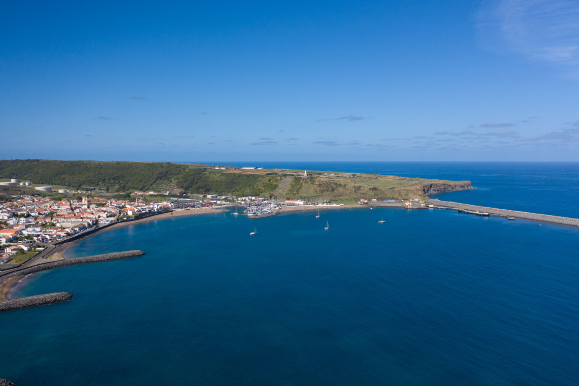 Aerial view of the sheltered bay and marina of Praia da Vit&oacute;ria with the town, sandy beach, and deep blue Atlantic Ocean, east coast of Terceira Island, Azores