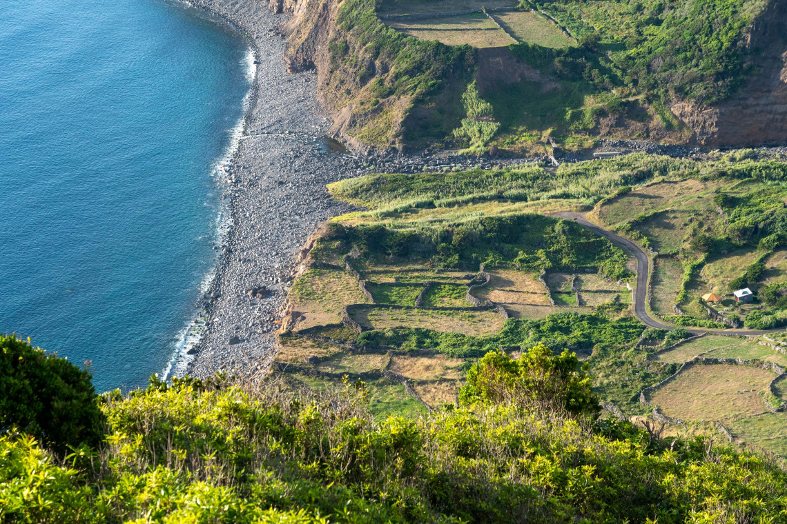 Aerial view of Faj&atilde; Grande on the west coast of Flores Island, with dramatic green cliffs, terraced fields, and rocky Atlantic shoreline, the westernmost village in Europe, Azores