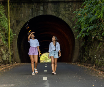 Two travelers walking through the Túnel da Caldeira on Graciosa Island, a road tunnel providing access to the interior of the island’s volcanic caldera.