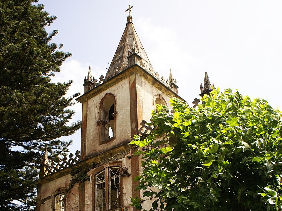 Ruined tower of Igreja de S&atilde;o Mateus in Ribeirinha on Faial Island, surrounded by trees and vegetation. The church was severely damaged by the 1998 Faial earthquake.