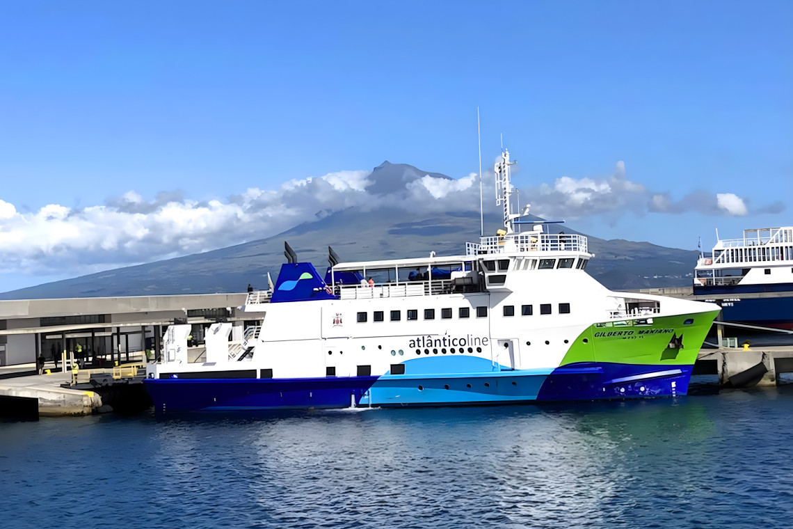 Ferry de Atl&acirc;nticoline atracado en Faial, Azores, con el volc&aacute;n de la Isla del Pico visible al fondo.