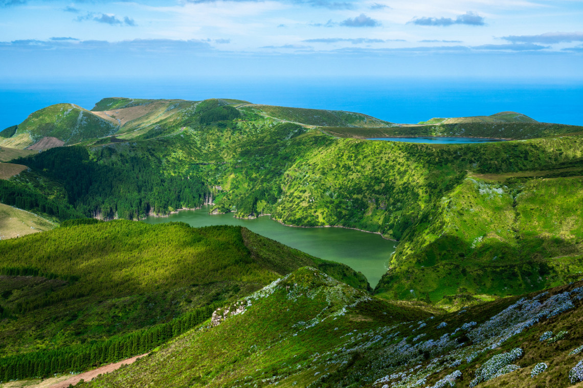 Panoramic view of Lagoas Funda e Rasa in Lajes das Flores on Flores Island, Azores, Portugal. The volcanic crater lakes are surrounded by forested slopes and green highlands overlooking the Atlantic Ocean.