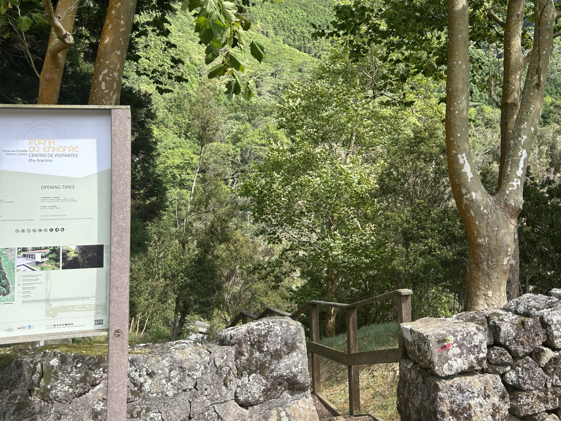 Entrance to the Furna do Enxofre Visitors Centre in S&atilde;o Mateus, Graciosa, with an information panel and stone steps leading through the forested interior of the caldera.