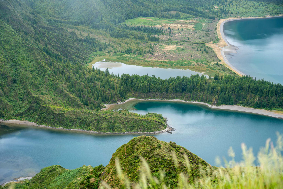Elevated view over Lagoa do Fogo on S&atilde;o Miguel Island, showing the crater lake, forested slopes and green volcanic landscape surrounding the water.