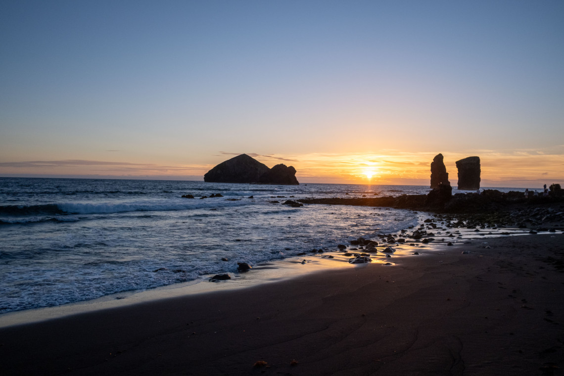 Sunset over Mosteiros Beach on S&atilde;o Miguel Island, with Atlantic waves, dark volcanic sand and the distinctive Mosteiros Islets offshore.