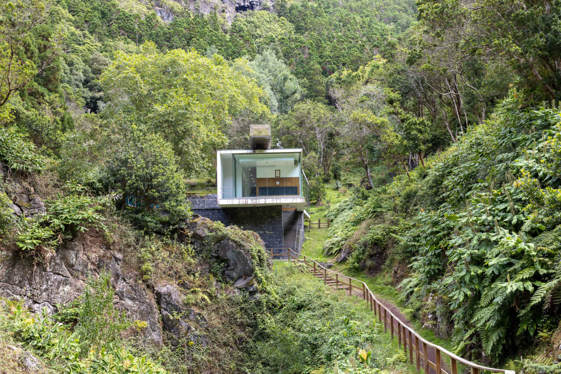 Furna do Enxofre Visitors Centre surrounded by dense vegetation inside Caldeira da Graciosa, with a wooden path leading through the volcanic landscape.