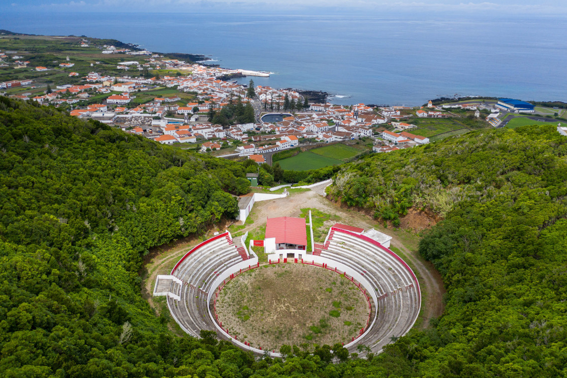 Elevated view of the circular Pra&ccedil;a de Touros da Graciosa on Monte de Nossa Senhora da Ajuda, with Santa Cruz da Graciosa and the Atlantic coast beyond.