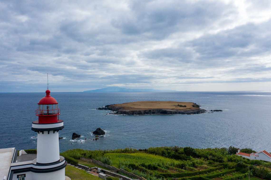 Ponta do Topo Lighthouse on the eastern end of S&atilde;o Jorge Island overlooking the Atlantic Ocean, with Ilh&eacute;u do Topo visible just offshore.