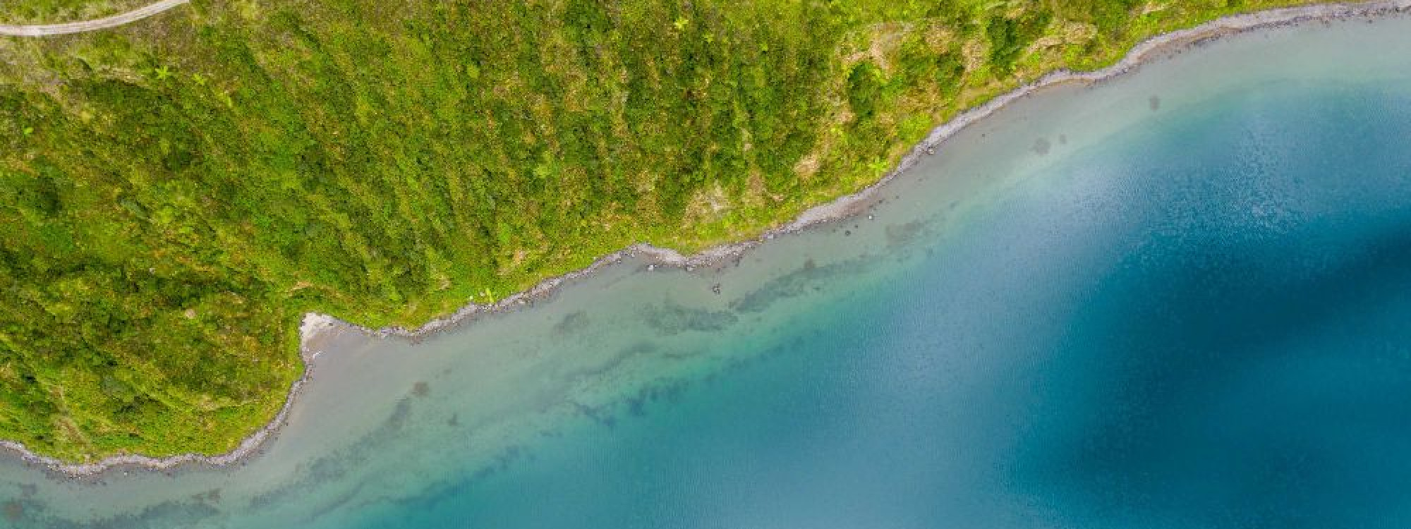 Vista aérea de la Lagoa do Fogo durante una ruta de senderismo en la isla de São Miguel, Azores, rodeada de paisaje volcánico y vegetación verde
