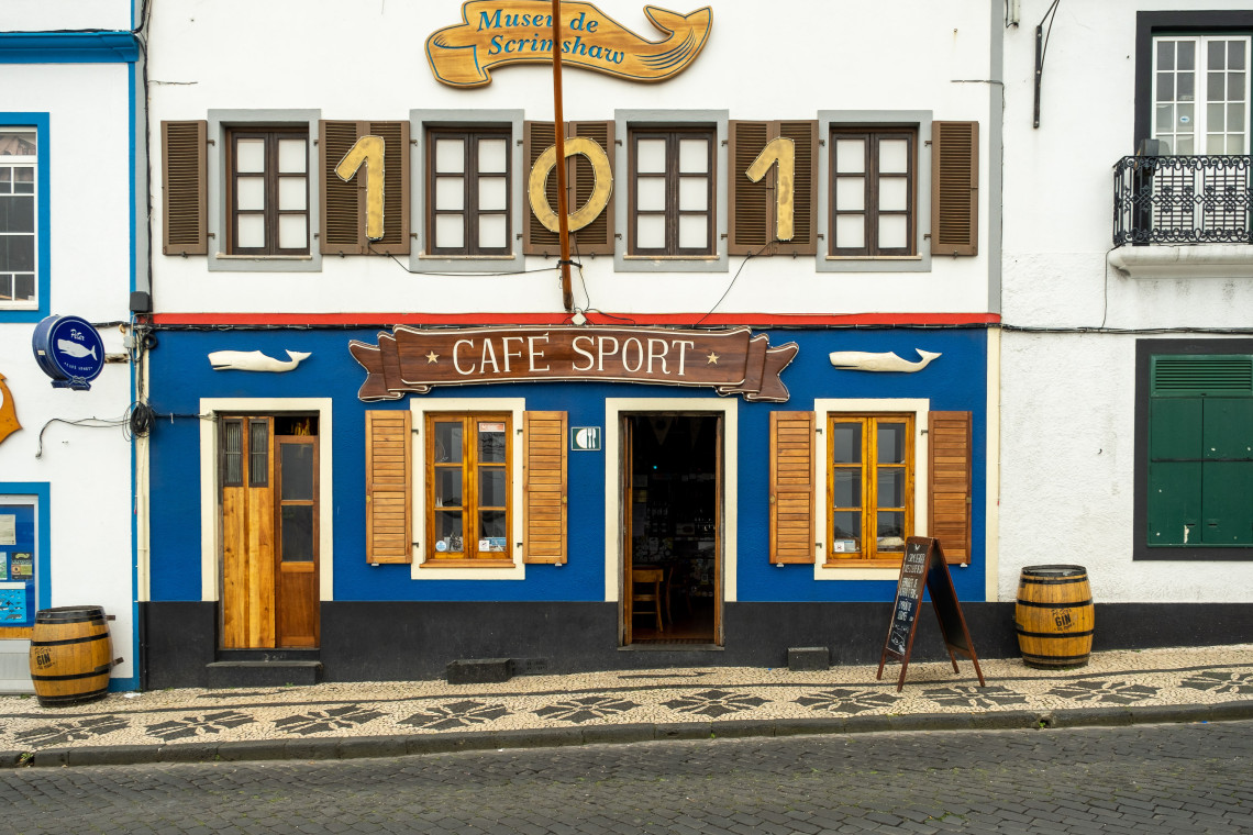 Exterior of Peter Caf&eacute; Sport in Horta, Faial, with its distinctive blue fa&ccedil;ade, wooden shutters and maritime details along the waterfront.