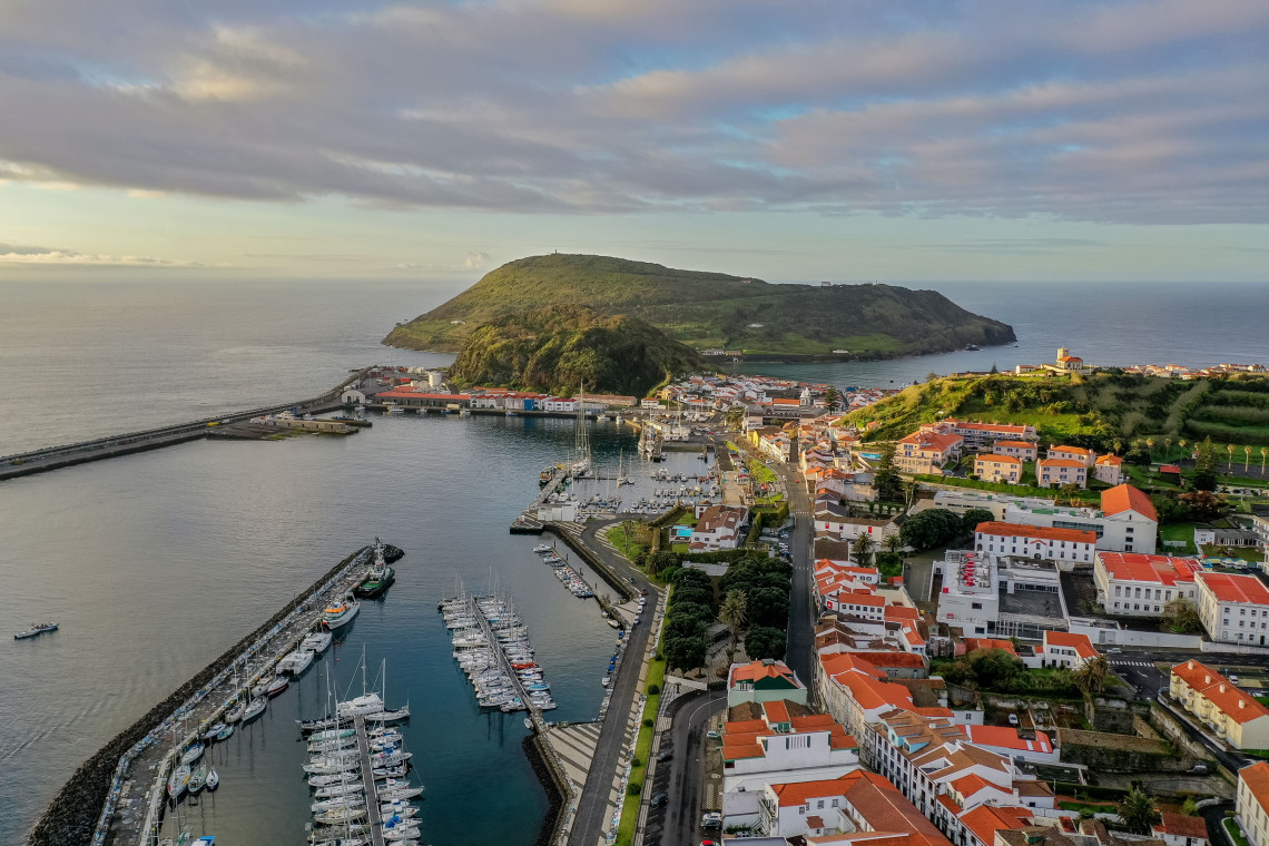 Elevated view over Horta Bay on Faial Island, Azores, Portugal, showing the marina, waterfront neighborhoods and Monte da Guia extending into the Atlantic.