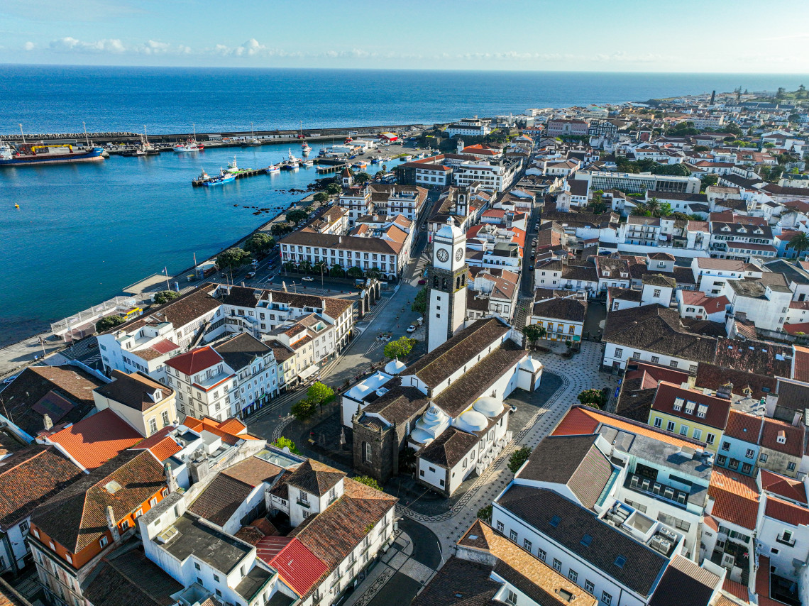 Aerial view of central Ponta Delgada, with the Igreja Matriz de S&atilde;o Sebasti&atilde;o, traditional red-roofed buildings and the waterfront visible beside the Atlantic Ocean.