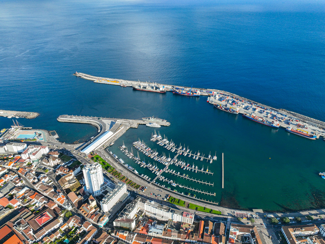 Aerial view of Ponta Delgada Marina and Portas do Mar, with rows of sailboats, the harbor and the deep blue Atlantic Ocean surrounding the city waterfront.