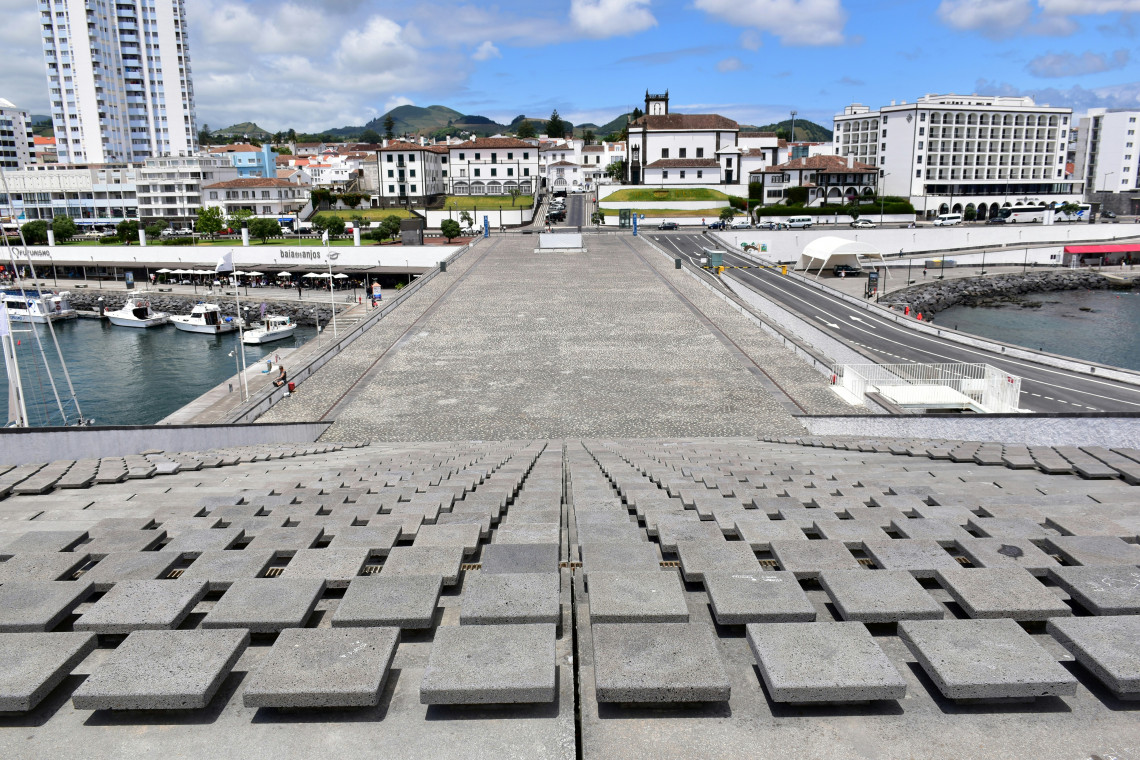 View across a waterfront square in Ponta Delgada, with the marina, traditional architecture and historic city center beside the Atlantic Ocean.