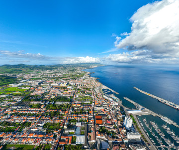 Aerial view of Ponta Delgada on São Miguel Island, showing the city, marina, harbor and Atlantic coastline stretching into the distance.