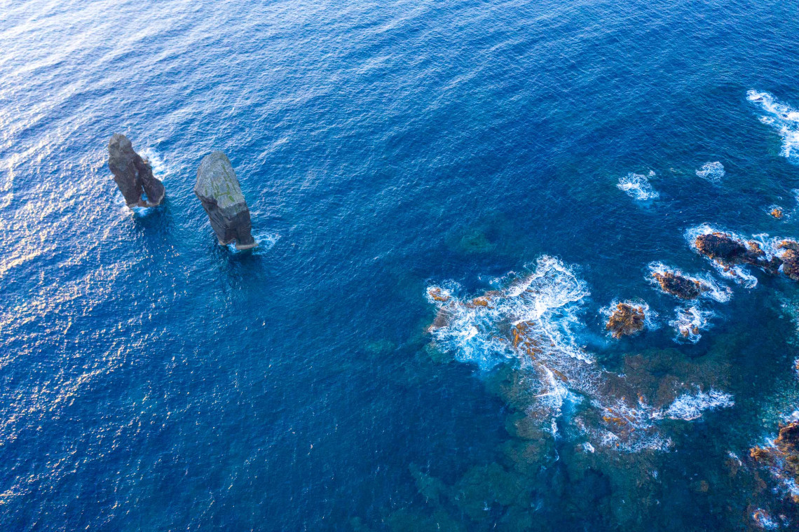 Aerial view of volcanic sea stacks rising from the blue Atlantic Ocean off the coast of Mosteiros on S&atilde;o Miguel Island.