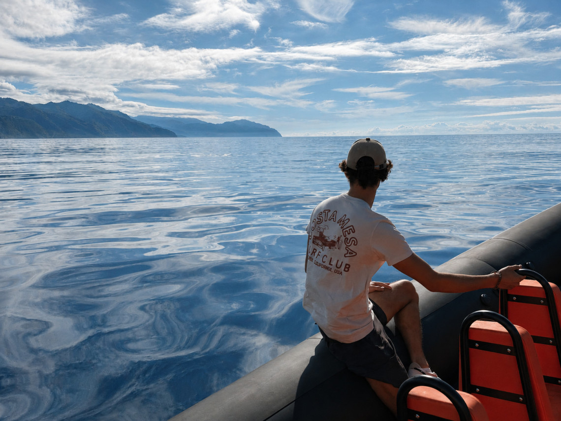 Passenger aboard a boat tour off S&atilde;o Miguel Island, looking across calm Atlantic waters toward the island&rsquo;s mountainous coastline.