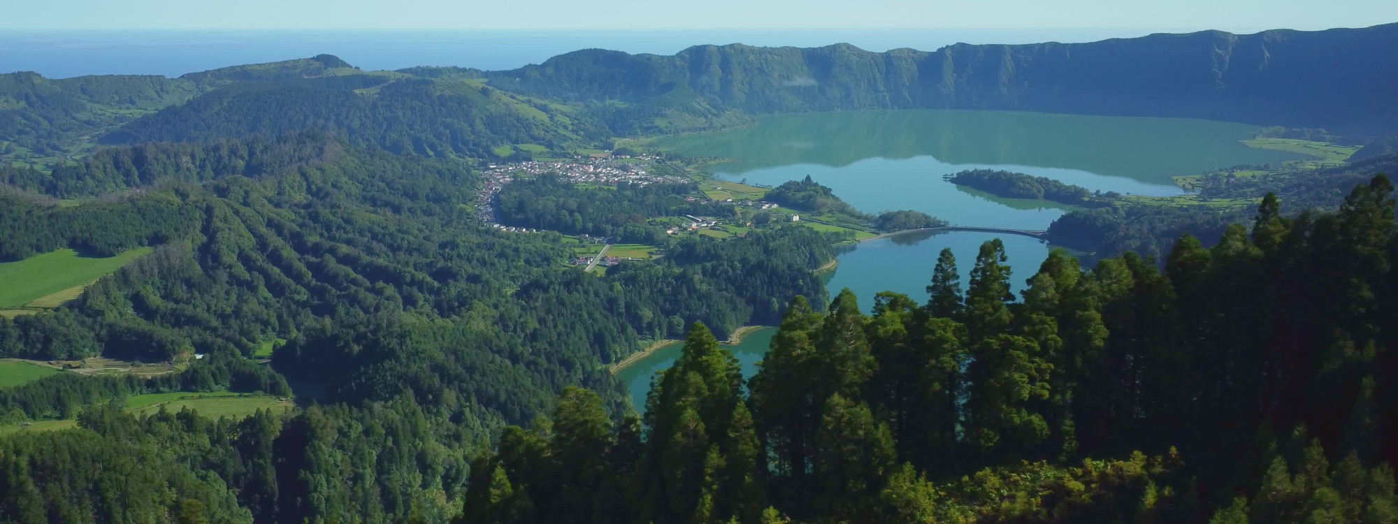 Panoramic view over Lagoa das Sete Cidades from Vista do Rei, with the twin volcanic lakes, village and forested crater walls stretching across the landscape.