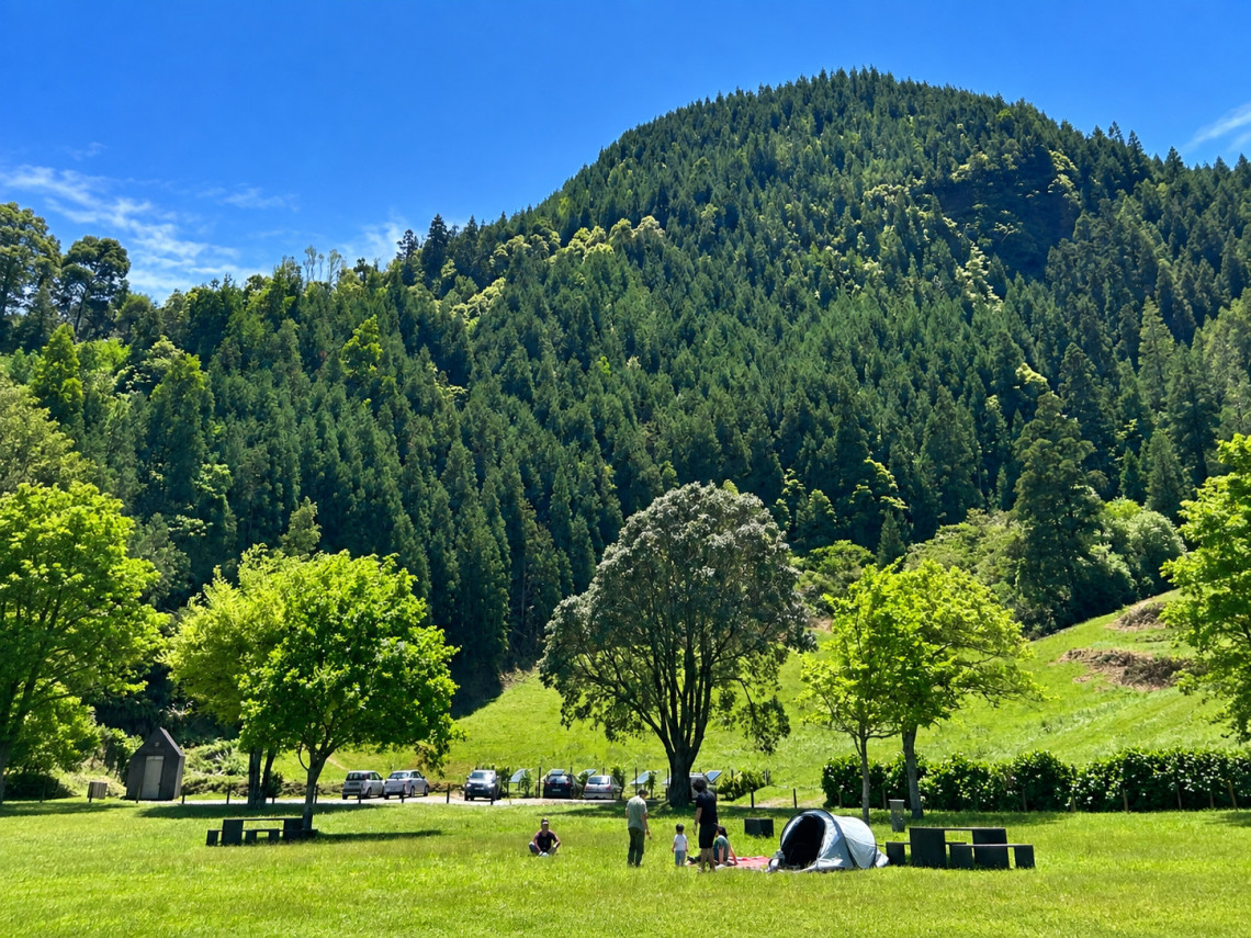 Green recreation area in Mata do Can&aacute;rio on S&atilde;o Miguel Island, with open lawns, picnic spaces and dense forest covering the surrounding volcanic hills.