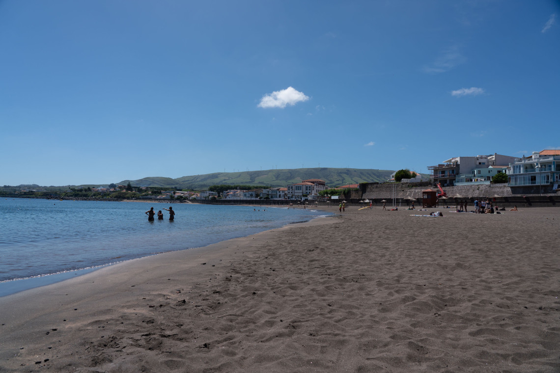 Praia Grande in Praia da Vit&oacute;ria on Terceira Island, with a broad sandy shoreline, calm bay and green hills rising behind the coastal city.